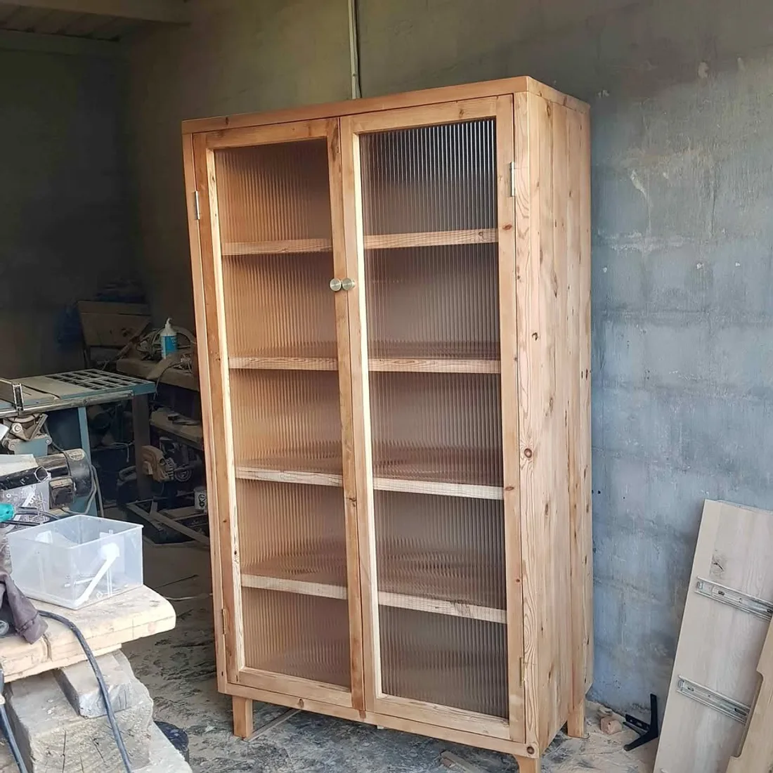 An Oregon pine display cabinet with reeded-glass doors in the workshop